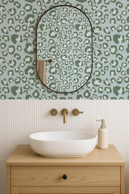 a bathroom with a white oval-shaped sink, a mirror above it, and a wooden vanity below. The wall behind the sink has a leopard print pattern.