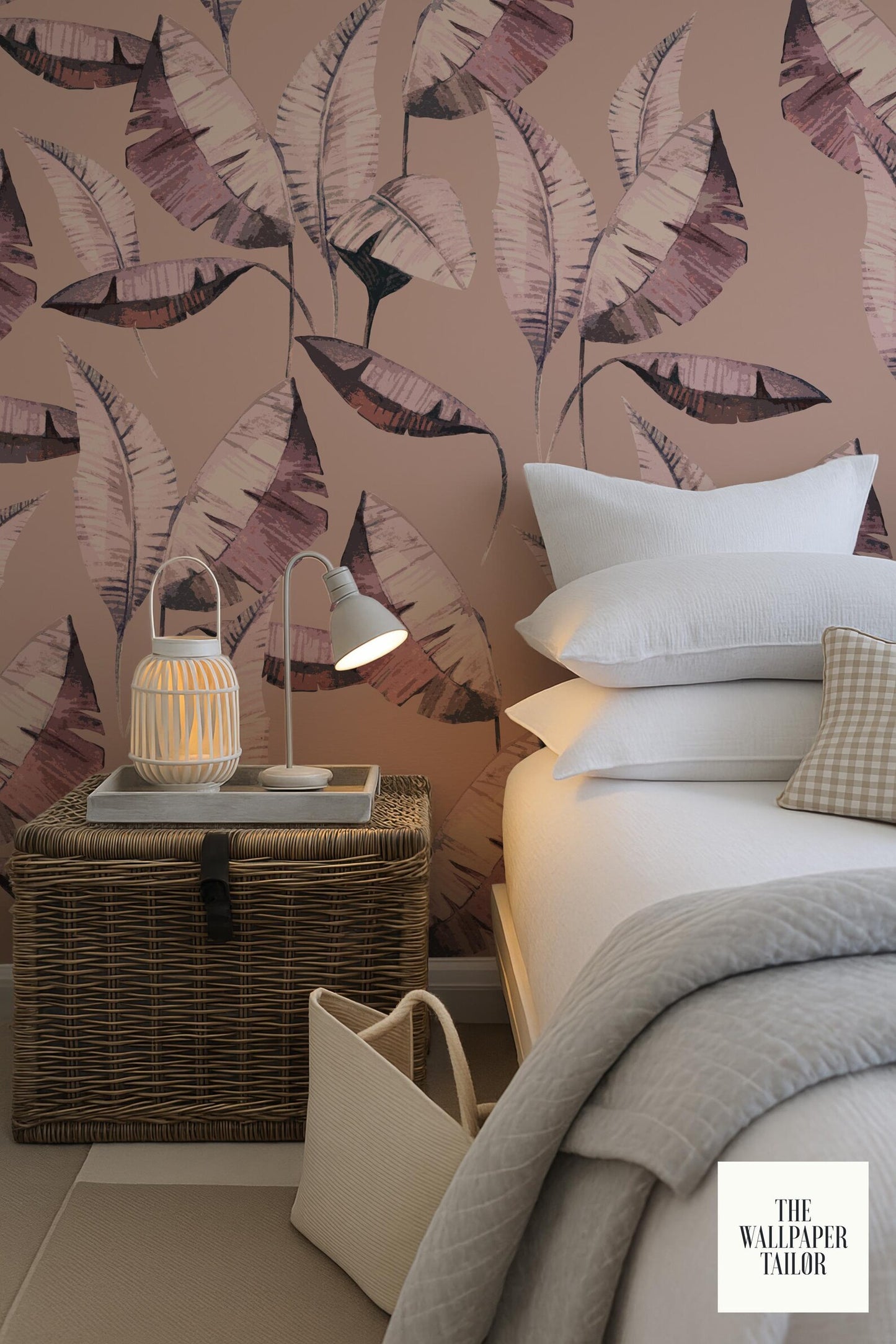 a bedroom with a bed, a nightstand, and a wicker basket. The wall behind the bed has a large, colorful, leaf-patterned wallpaper.