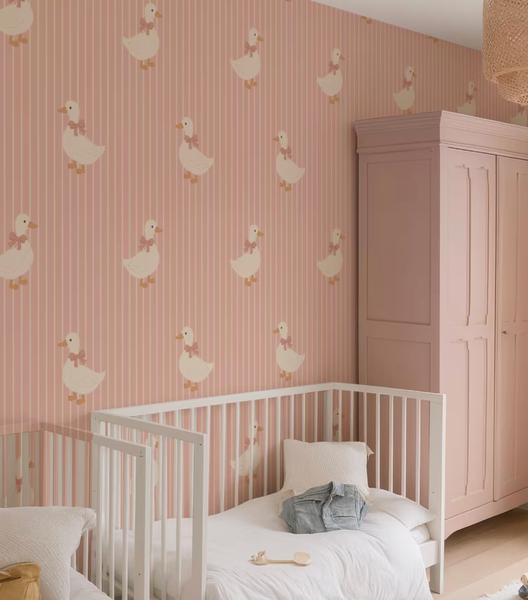a nursery room with a white crib and a pink striped wallpaper featuring white ducks.