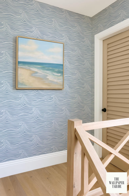 a coastal-themed room with a framed painting of a beach scene on the wall, a wooden staircase, and a door with a beige frame.