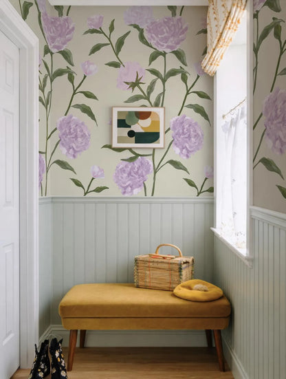 a cozy and charming hallway with a floral wallpaper pattern in shades of purple and green. A yellow bench is situated in the corner, and a woven basket rests on it. A framed abstract artwork hangs on the wall above the bench, adding a touch of artistic flair to the space.