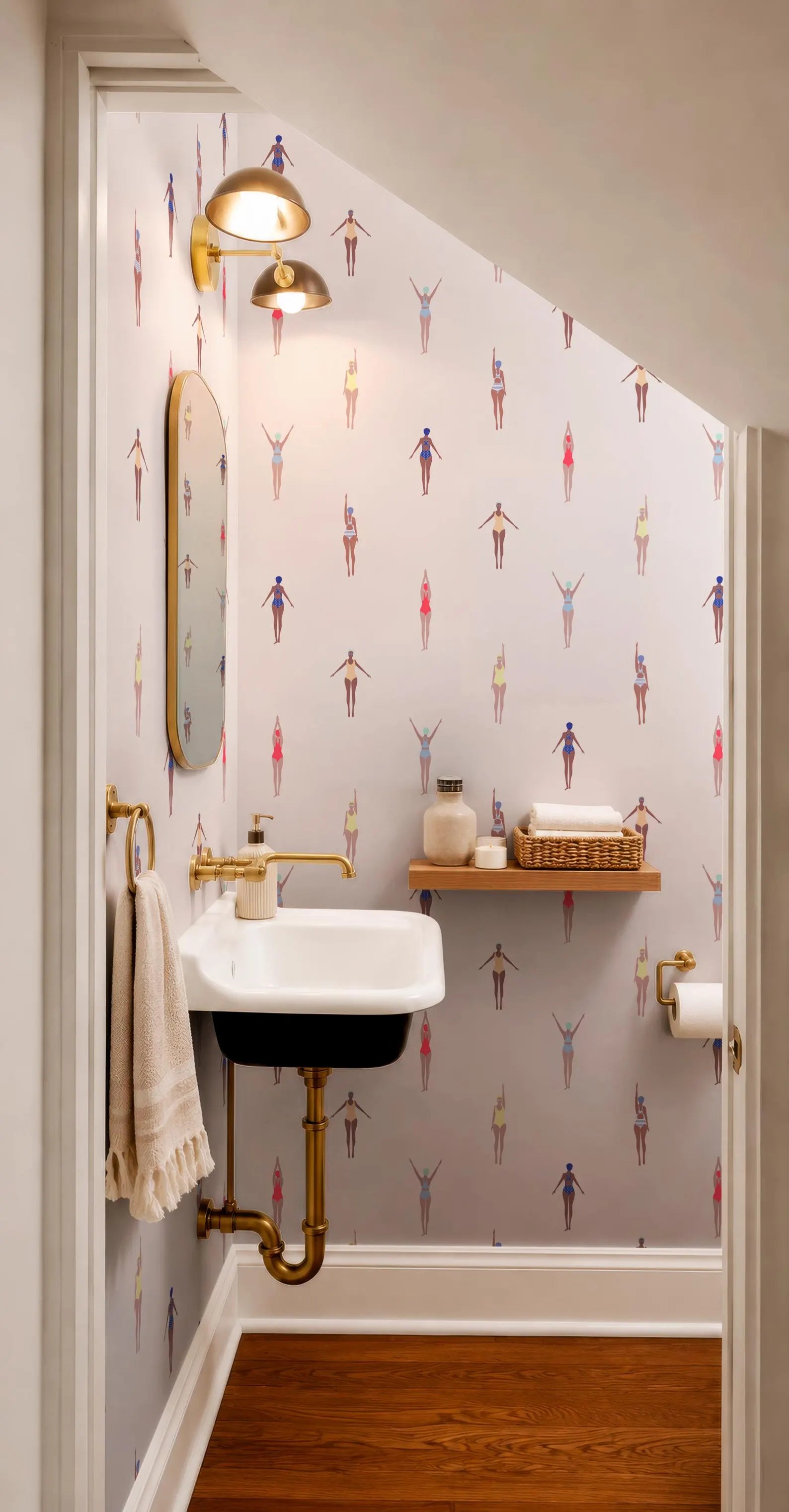 a bathroom with a unique wallpaper pattern featuring stylized human figures. The bathroom has a white sink, a mirror, and a shelf with toiletries. The overall design and color scheme create a visually appealing and modern aesthetic.