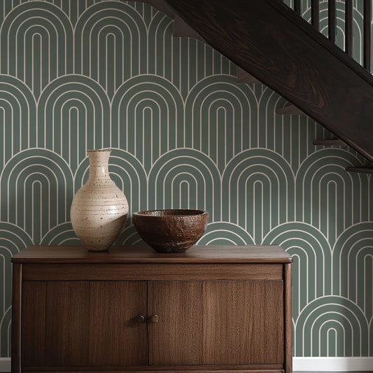 a wooden cabinet with a white vase and a brown bowl placed on top of it, set against a wall with a repeating green and white wave pattern.