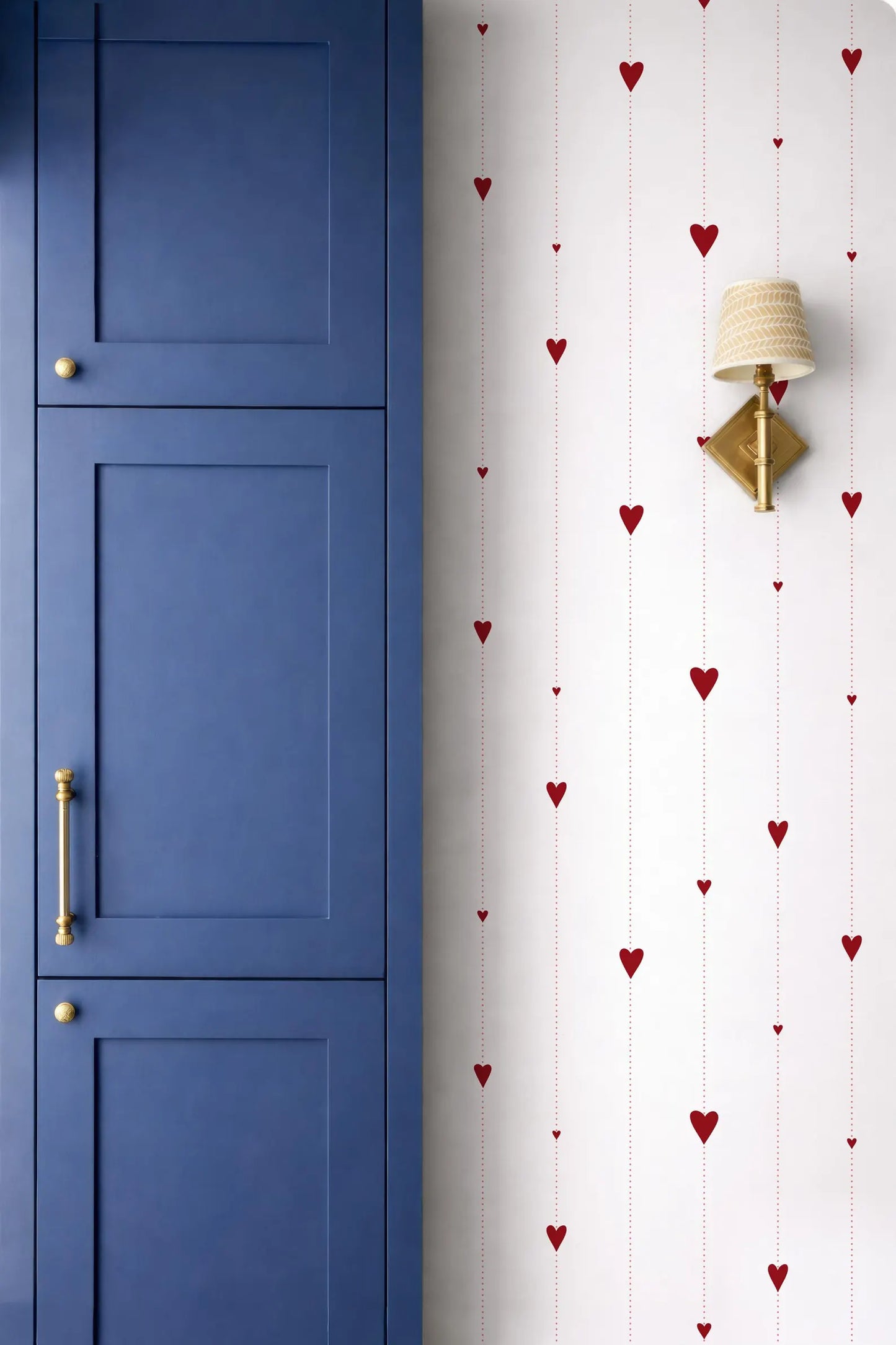 a blue cabinet door and a wall with a pattern of red hearts on it.