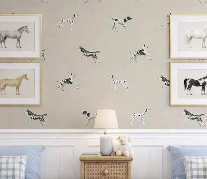 a wallpapered wall with a repeating pattern of black and white dogs, including a dachshund, a dachshund puppy, and a dachshund. Above the wall, there are four framed pictures of horses, including a white horse, a brown horse, a black and white horse, and a brown horse. In front of the wall, there is a wooden nightstand with a lamp and a stuffed animal.
