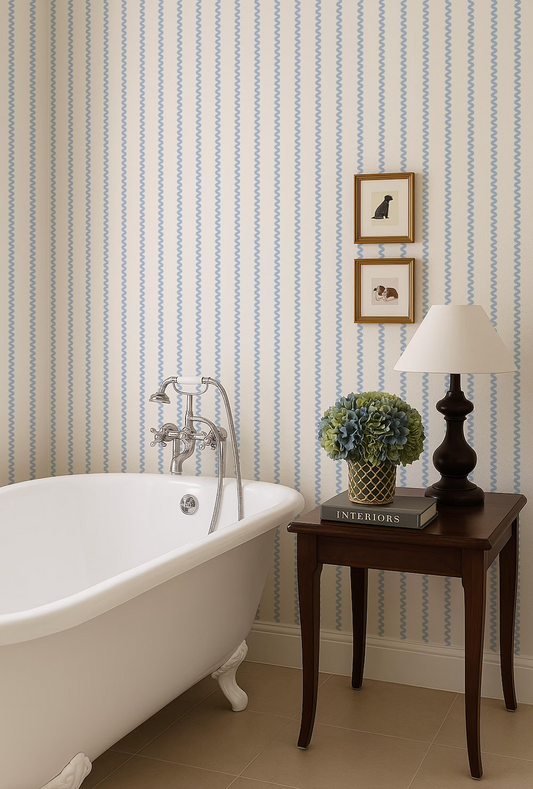 a bathroom with a clawfoot bathtub, a wooden side table with a lamp, and a framed picture on the wall.