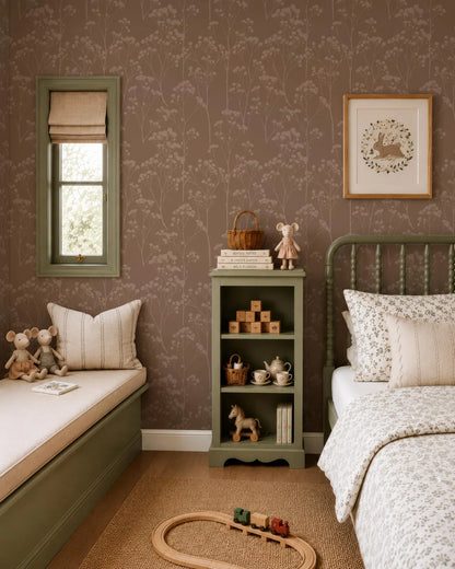 a cozy and charming bedroom with a bed, a bookshelf, and a window. The room has a warm and inviting atmosphere, with a floral wallpaper and a wooden floor. The bed is adorned with a white comforter and pillows, and there are two stuffed animals on the bed. The bookshelf is filled with various books and toys, creating a space for both relaxation and play. The window is dressed with a white curtain, allowing natural light to filter into the room.