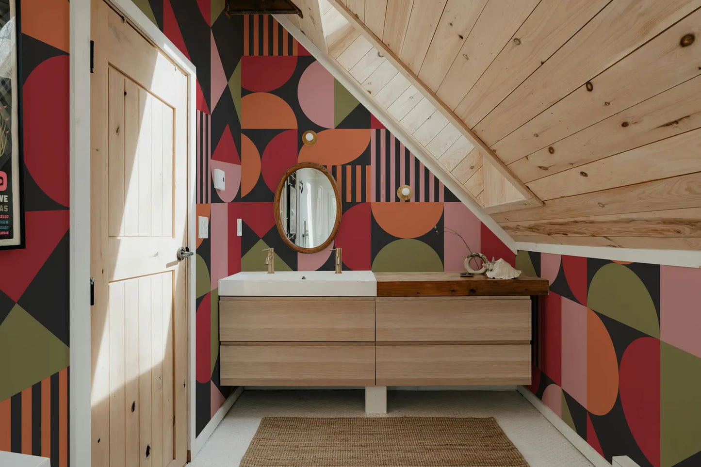 a bathroom with a wooden vanity and a colorful geometric pattern on the walls.