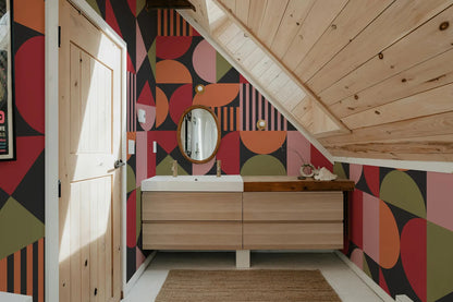 a bathroom with a wooden vanity and a colorful geometric pattern on the walls.