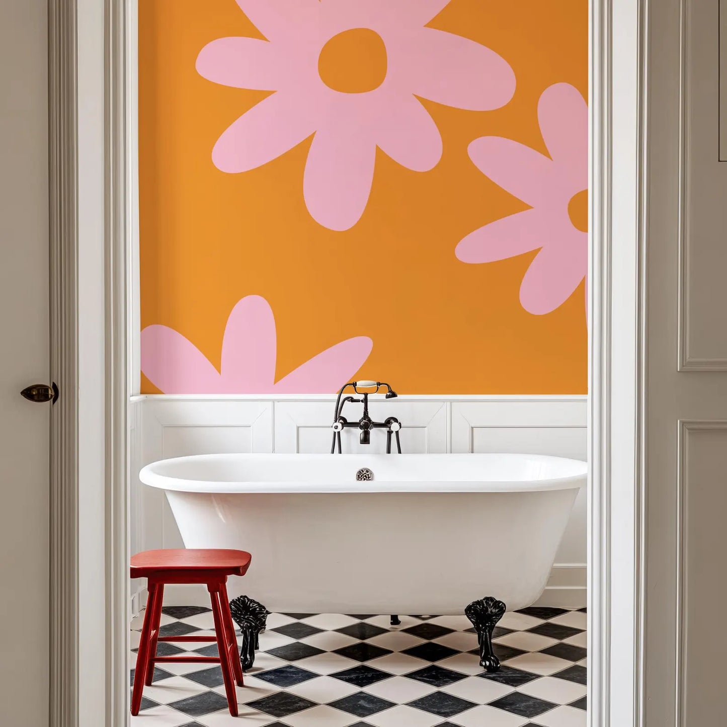 a bathroom with a white clawfoot bathtub, a red stool, and a black and white checkered floor. The walls are painted in a vibrant orange color with large pink flower-like designs.