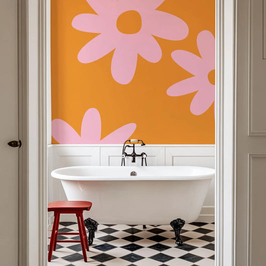 a bathroom with a white clawfoot bathtub, a red stool, and a black and white checkered floor. The walls are painted in a vibrant orange color with large pink flower-like designs.