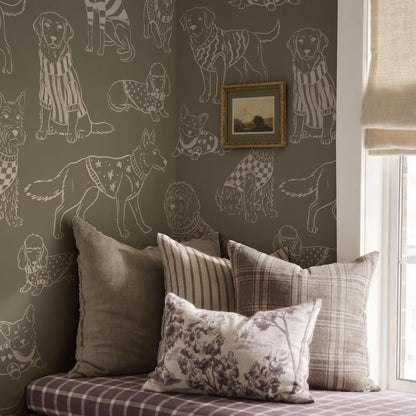 a wall with a repeating pattern of dogs in various outfits, creating a visually striking and whimsical design. The wall is adorned with a framed picture of a dog, adding a personal touch to the space. The room is furnished with a bed, a window, and a window shade, creating a cozy and inviting atmosphere.