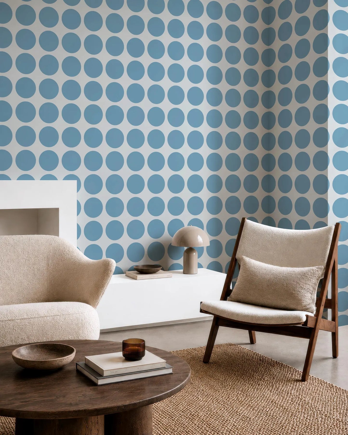 a modern living room with a white sofa, a wooden chair, and a round wooden coffee table. The walls are covered in a blue and white polka dot pattern, creating a vibrant and playful atmosphere. The room also includes a bookshelf, a lamp, and a rug, contributing to the overall aesthetic and comfort of the space.