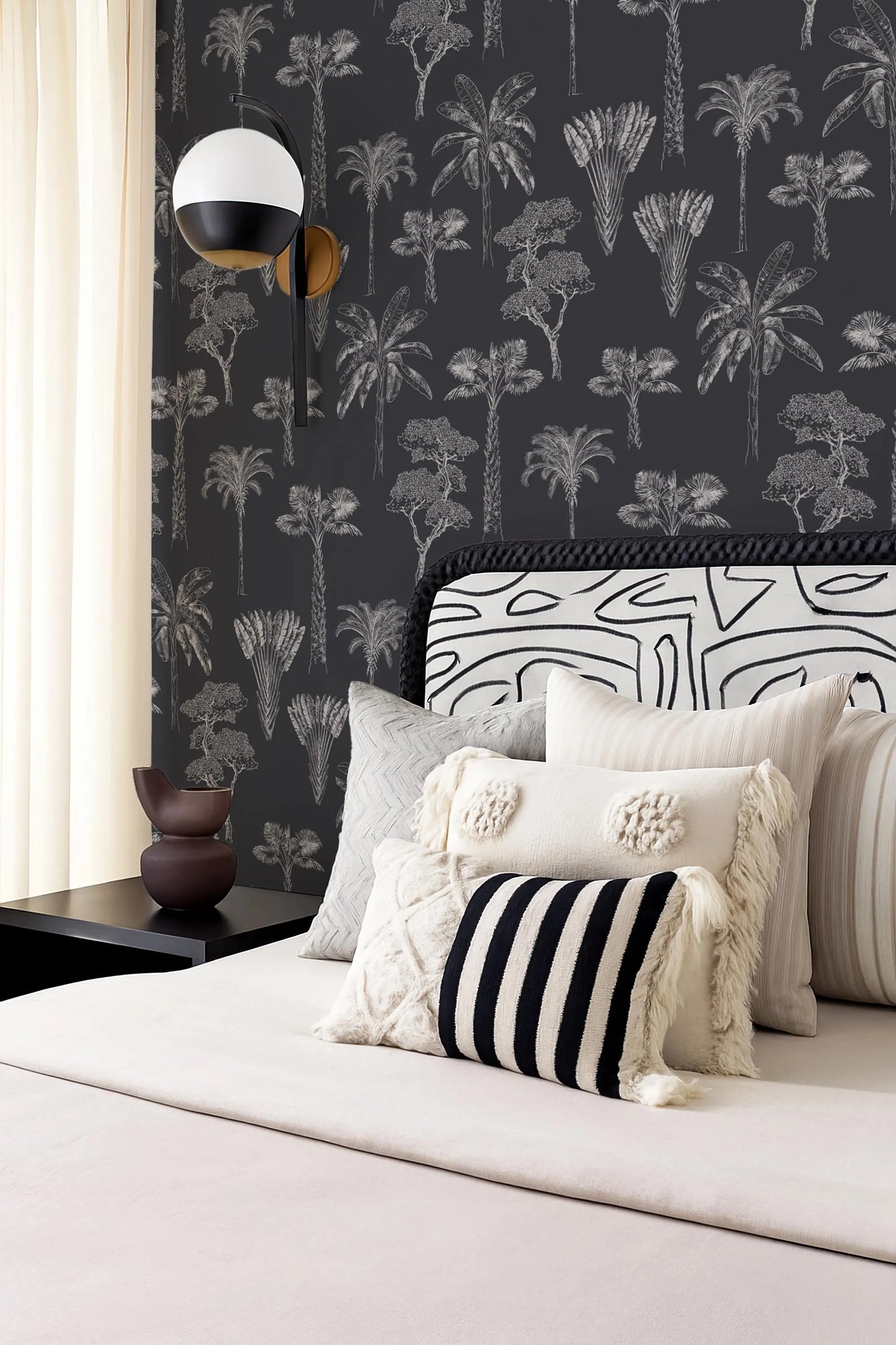 a bedroom with a black and white patterned wallpaper, a bed with a black and white striped pillow, and a black and white patterned headboard.