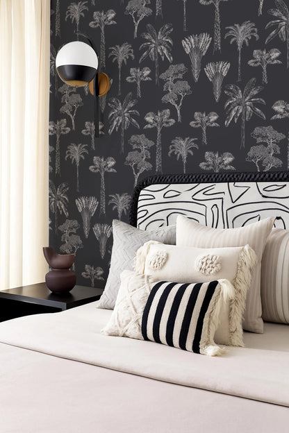 a bedroom with a black and white patterned wallpaper, a bed with a black and white striped pillow, and a black and white patterned headboard.