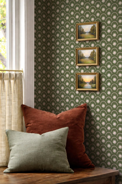 a cozy corner with a wooden table, a window with a curtain, and three framed pictures of landscapes hanging on the wall.