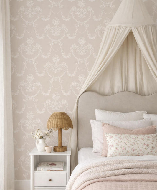 a cozy and inviting bedroom with a canopy bed, a white nightstand, and a lamp. The bed is adorned with a white comforter and pink pillows, creating a warm and feminine atmosphere. The room is decorated with a floral patterned wallpaper, adding a touch of elegance and charm.