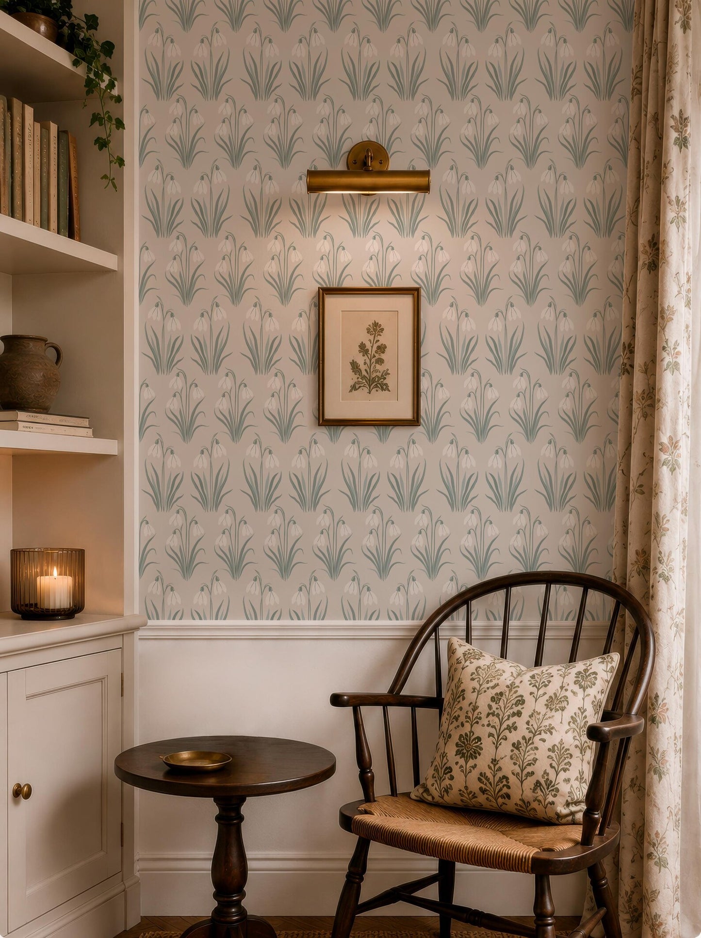 a cozy corner of a room with a wooden chair, a small round table, and a framed picture on the wall. The room has a patterned wallpaper and a bookshelf filled with books and decorative items.