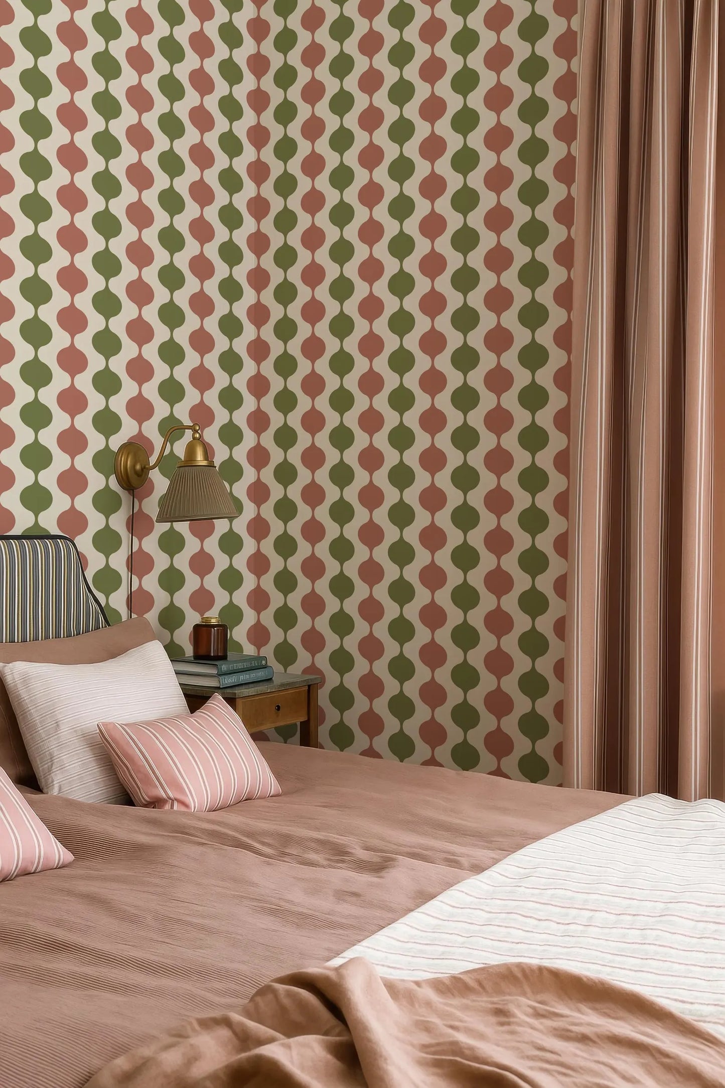 a bedroom with a bed, a nightstand, and a lamp. The walls are covered in a patterned wallpaper with a repeating design of circles in various colors, including shades of green, pink, and orange. The room has a cozy and inviting atmosphere.