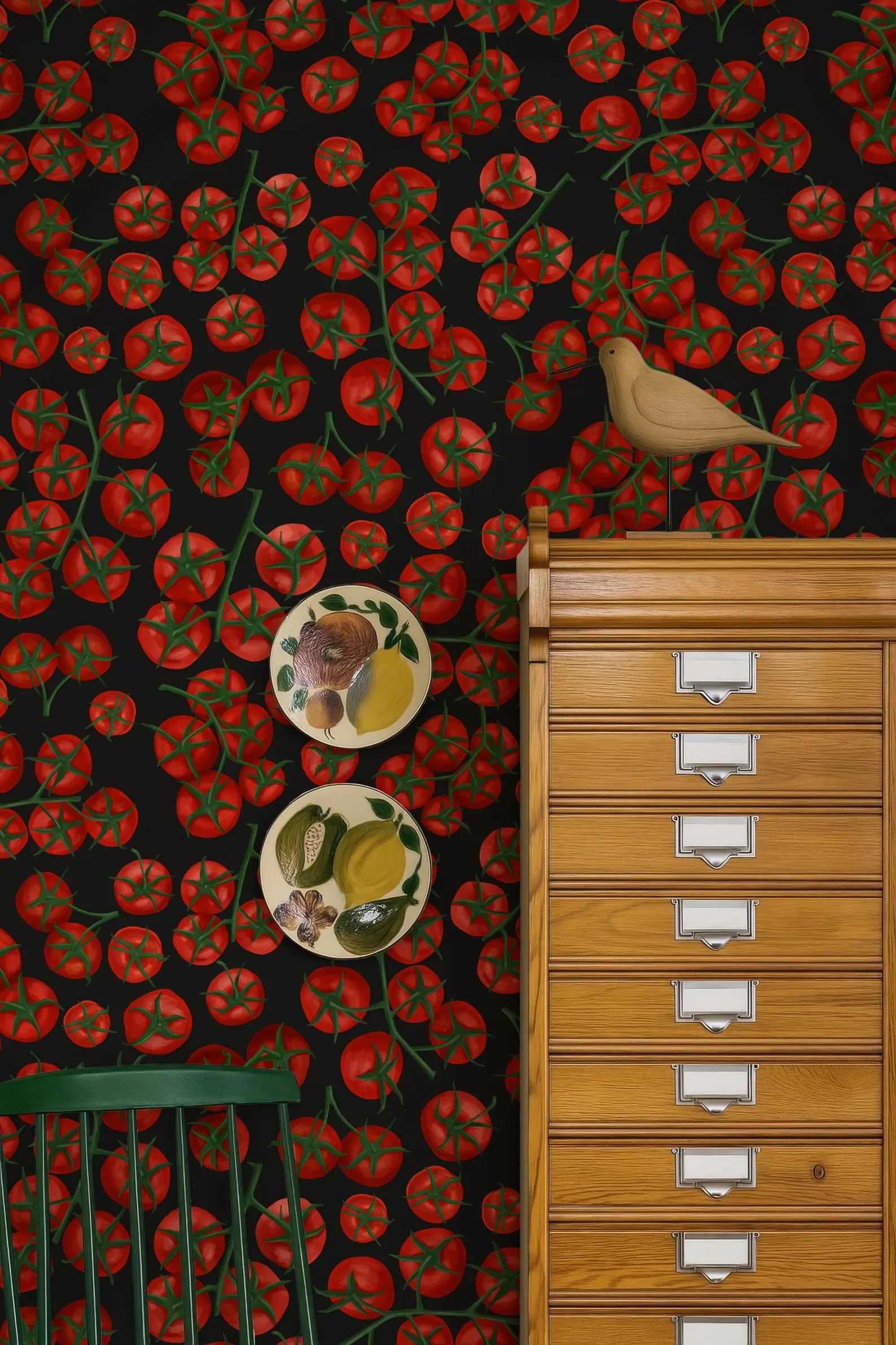a vibrant and colorful wallpapered wall with a wooden cabinet and a bird perched on top. The wall is adorned with a pattern of red tomatoes, and there are two plates with fruit designs placed on the wall.