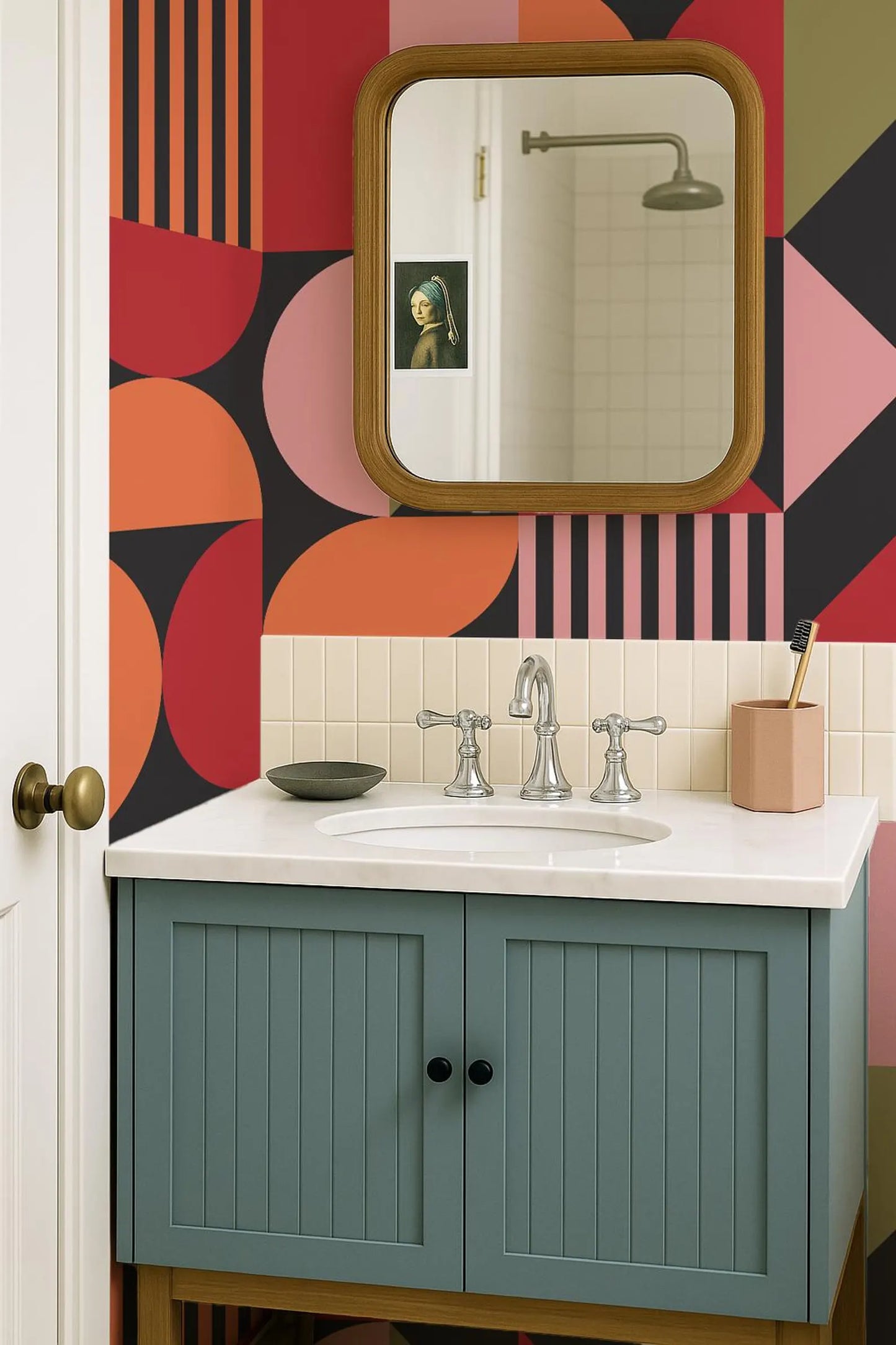 a bathroom with a colorful geometric pattern on the walls, a white sink with a silver faucet, and a mirror above the sink.