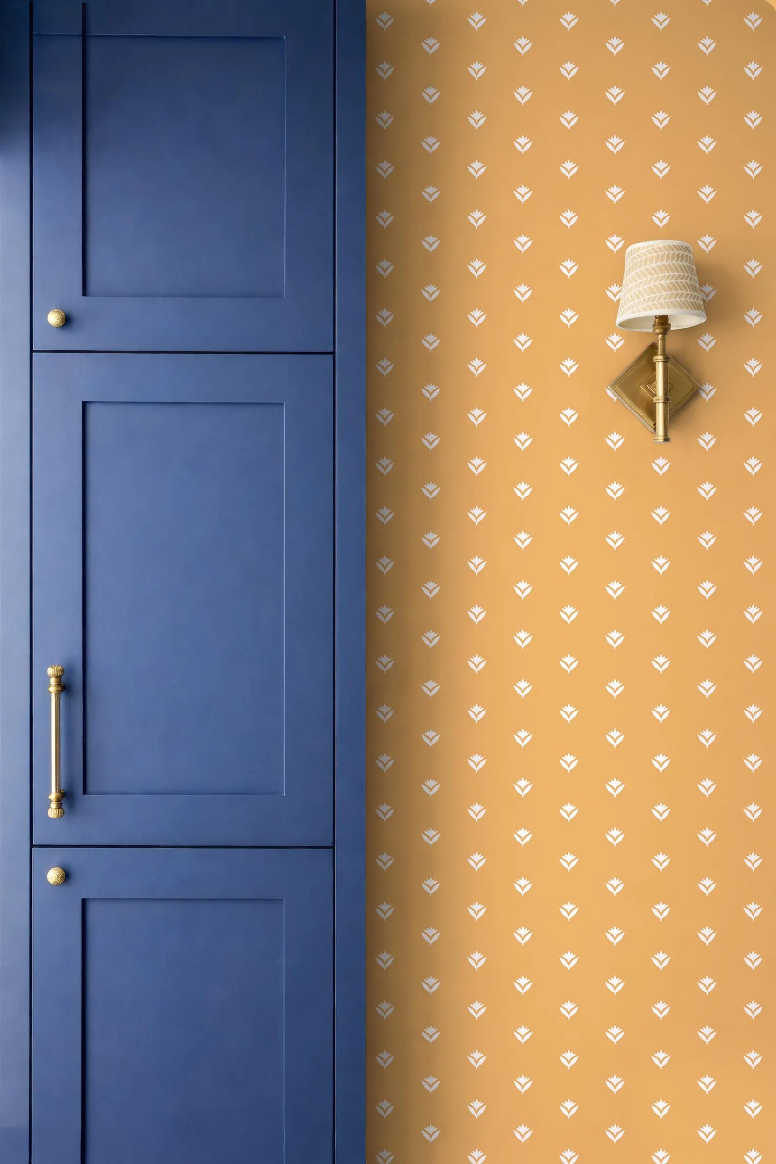 a blue cabinet door and a wall with a patterned wallpaper.