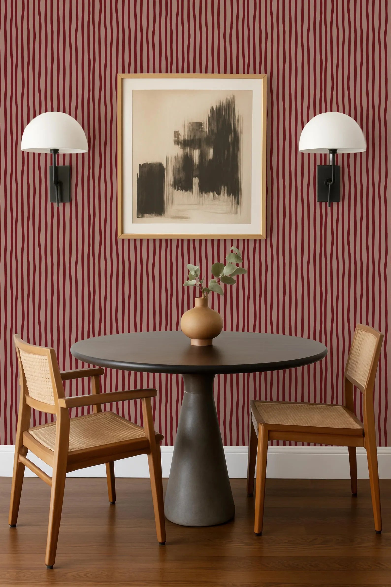 a modern dining area with a round table, two wooden chairs, and a framed abstract artwork on the wall above the table.