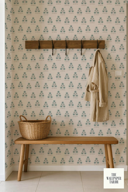 a wooden bench with a wicker basket on it, set against a wall with a patterned wallpaper. A coat is hanging on a wooden coat rack above the bench.