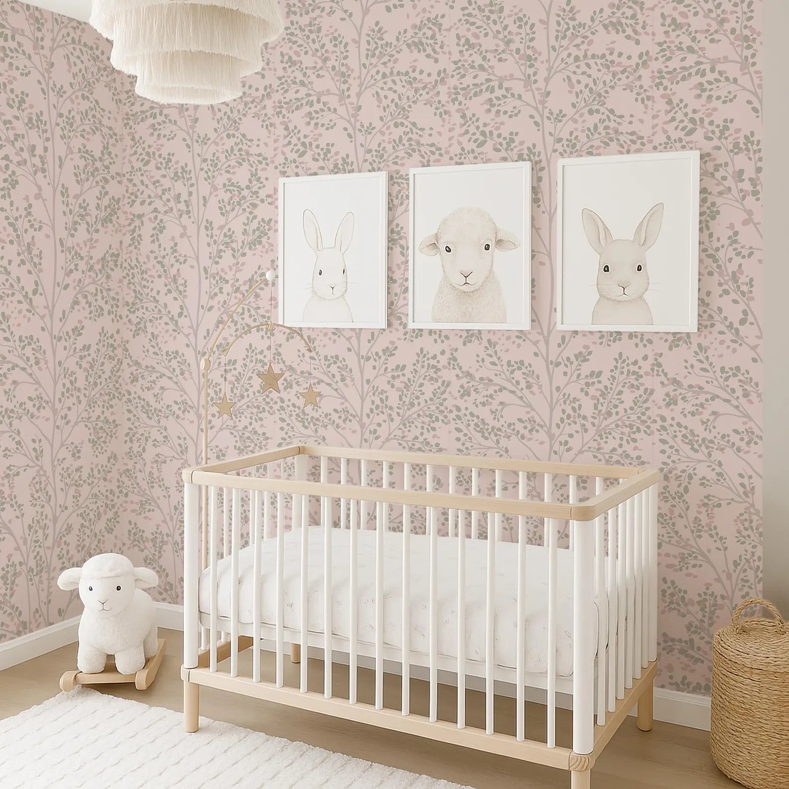 A cozy nursery with a white crib, a plush lamb, and three framed animal illustrations on the wall.