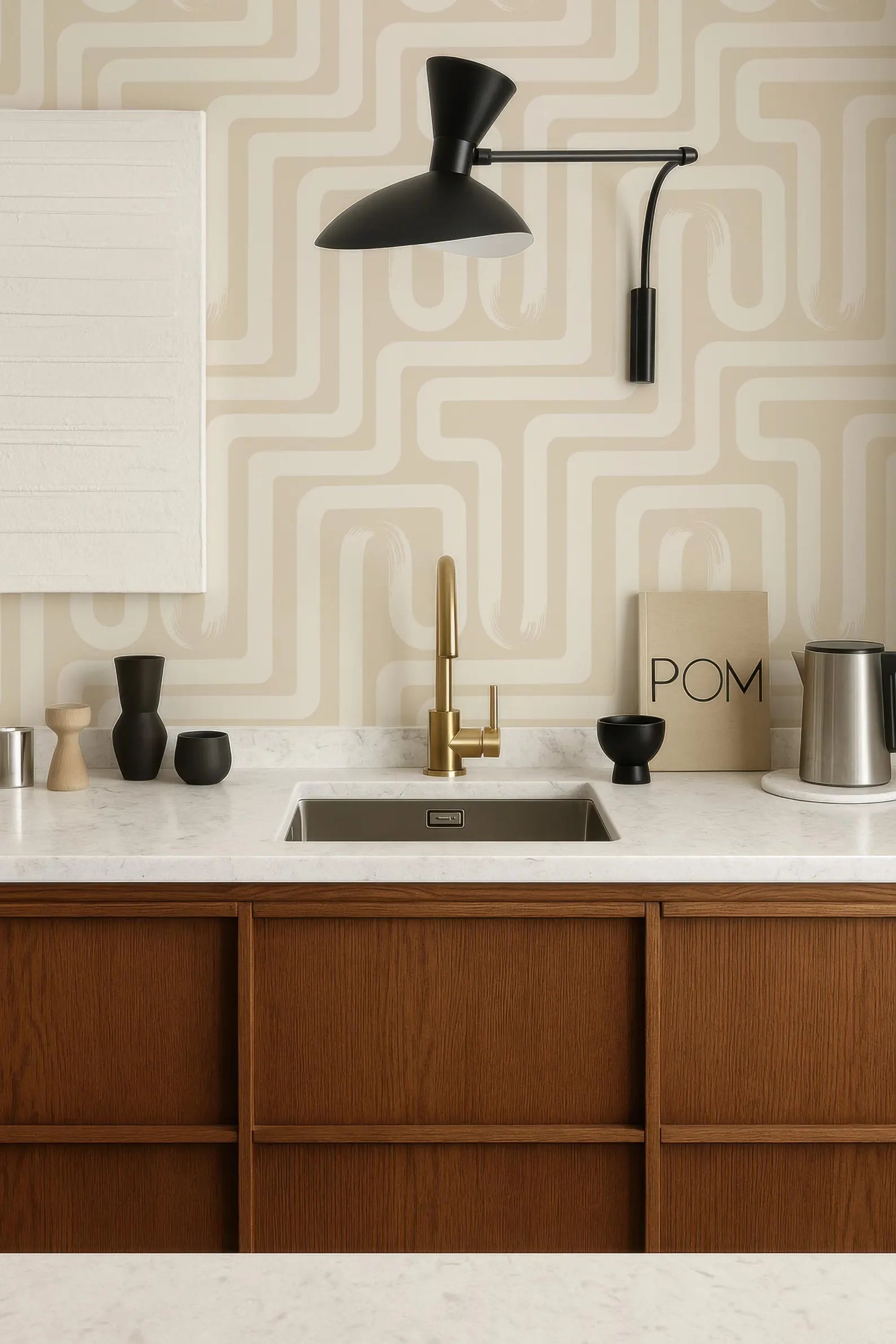 a modern kitchen with a wooden cabinet, a sink, and a black lamp. The walls are adorned with a geometric pattern wallpaper, and there are various decorative items on the countertop, including a bowl, a vase, and a coffee maker.