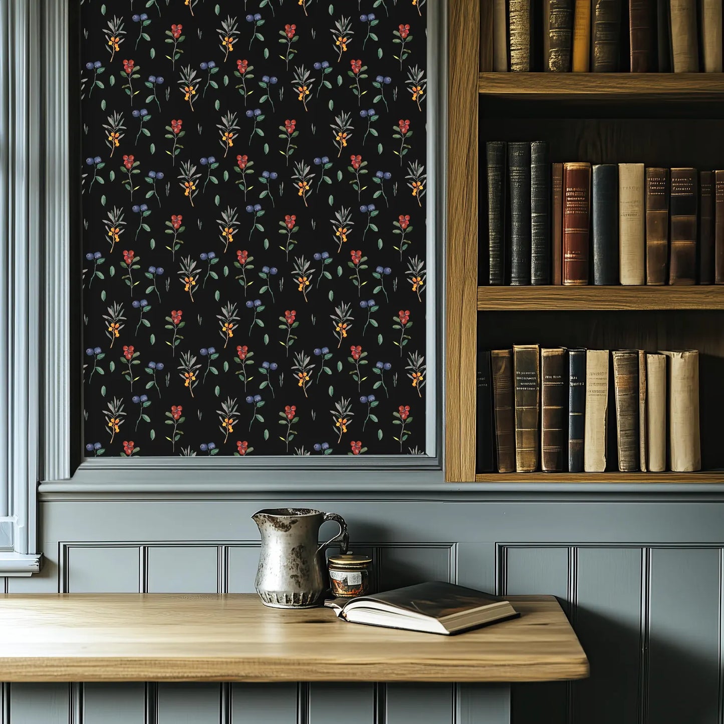 a bookshelf filled with books, a wooden table with a metal pitcher and a book, and a black floral patterned wallpaper.