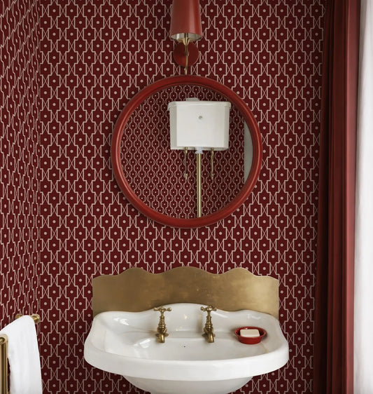 a bathroom with a white sink, a red circular mirror, and a red curtain. The walls are covered in a red and white patterned wallpaper.