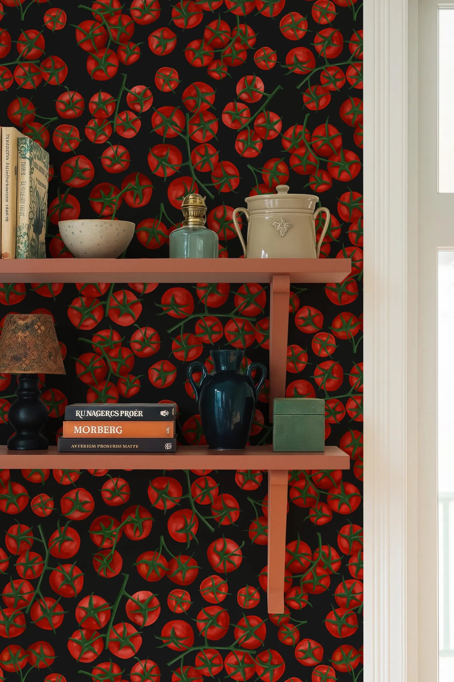 a shelf with various items on it, including a blue vase, a white pot, a stack of books, and a lamp. The shelf is set against a wall with a vibrant tomato wallpaper.
