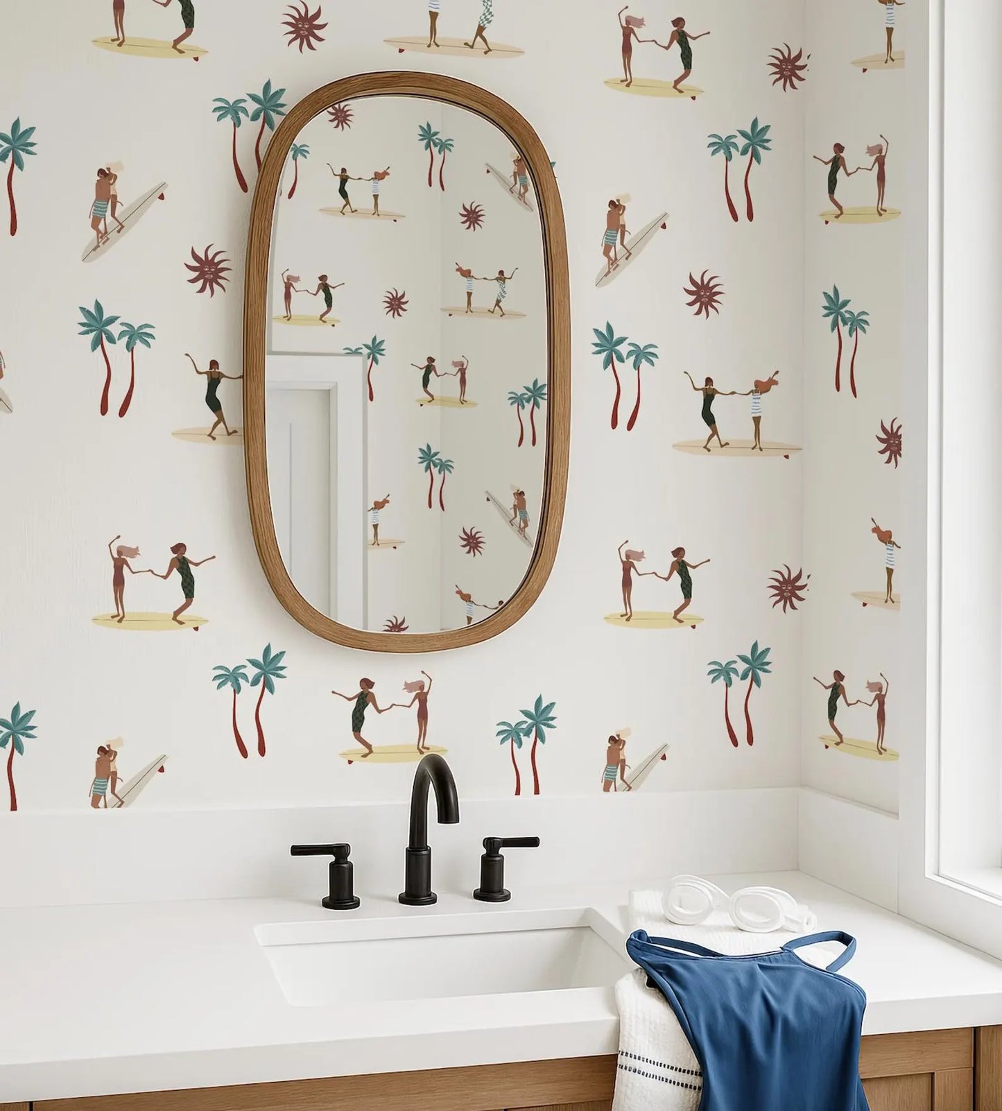a bathroom with a white sink, a mirror, and a towel. The wall behind the sink is decorated with a pattern of palm trees and people surfing.
