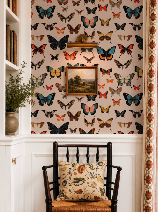 a room with a wallpapered wall adorned with a variety of colorful butterflies. A wooden chair with a floral pillow is positioned in front of the wall, and a small plant is placed on a shelf to the left of the chair.