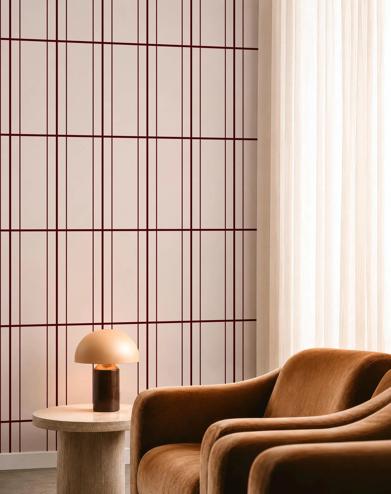 a modern living room with a brown leather armchair, a round wooden side table with a lamp, and a red and white checkered wall.