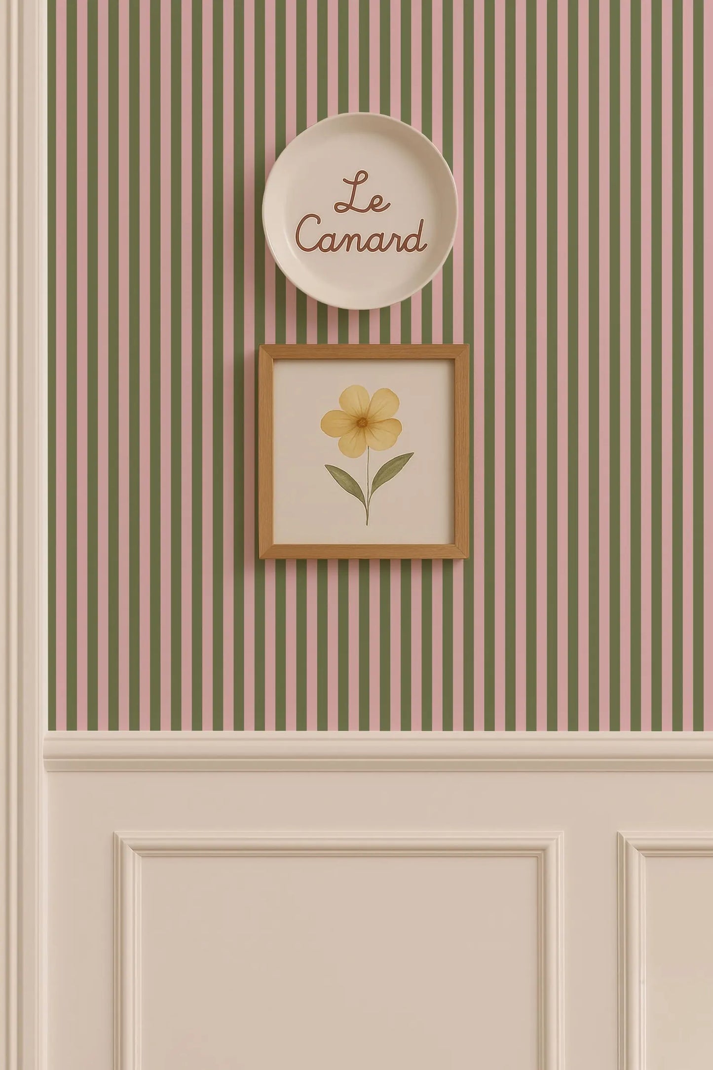 a wall with a framed picture of a yellow flower and a plate with the word "Le Camand" written on it.