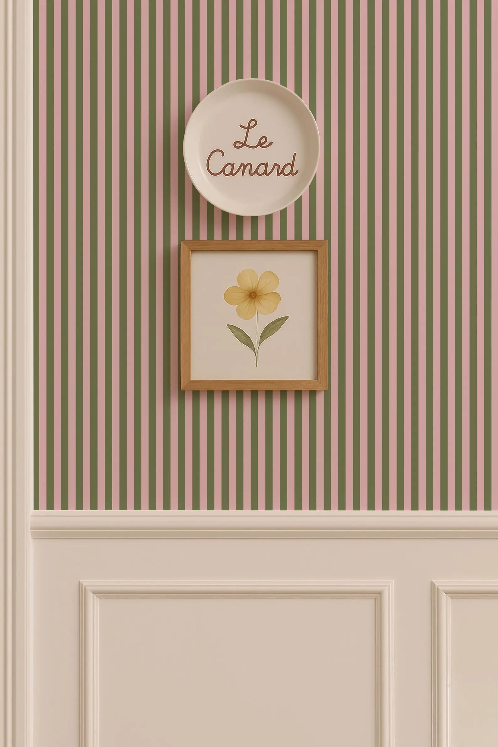 a wall with a framed picture of a yellow flower and a plate with the word "Le Camand" written on it.