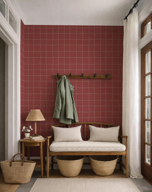 a cozy entryway with a red tiled wall, a wooden bench with two woven baskets, a lamp, and a coat rack.