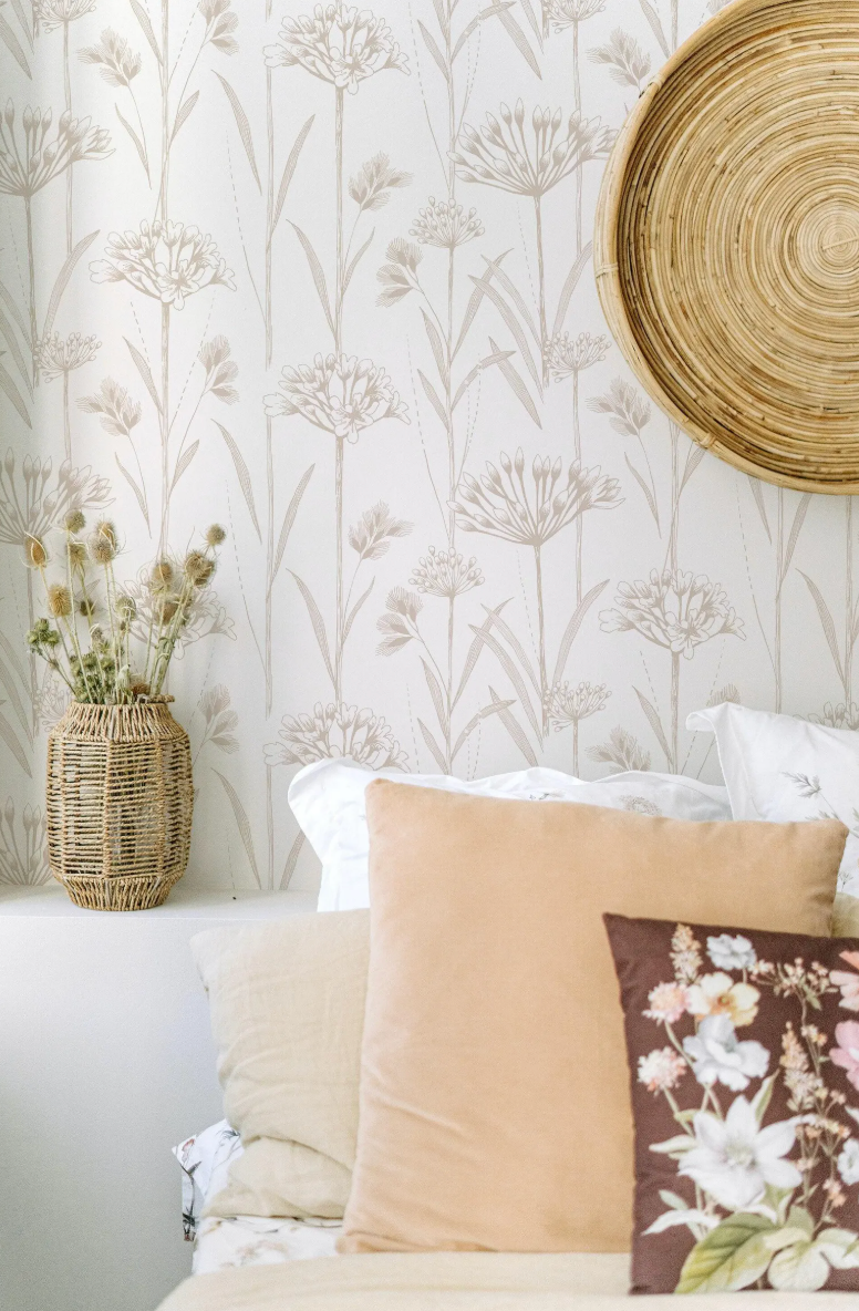 a cozy bedroom setting with a floral wallpaper, a woven basket, and a round woven basket on the wall.