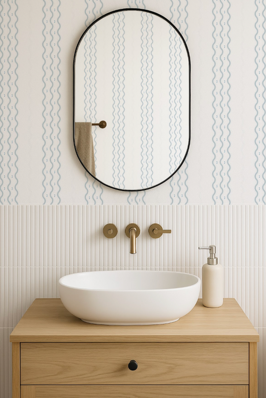 a modern bathroom with a white oval-shaped sink, a wooden vanity, and a black oval-shaped mirror above the sink.