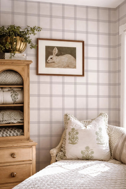 a cozy bedroom with a wooden dresser, a framed picture of a rabbit, and a bed with decorative pillows.