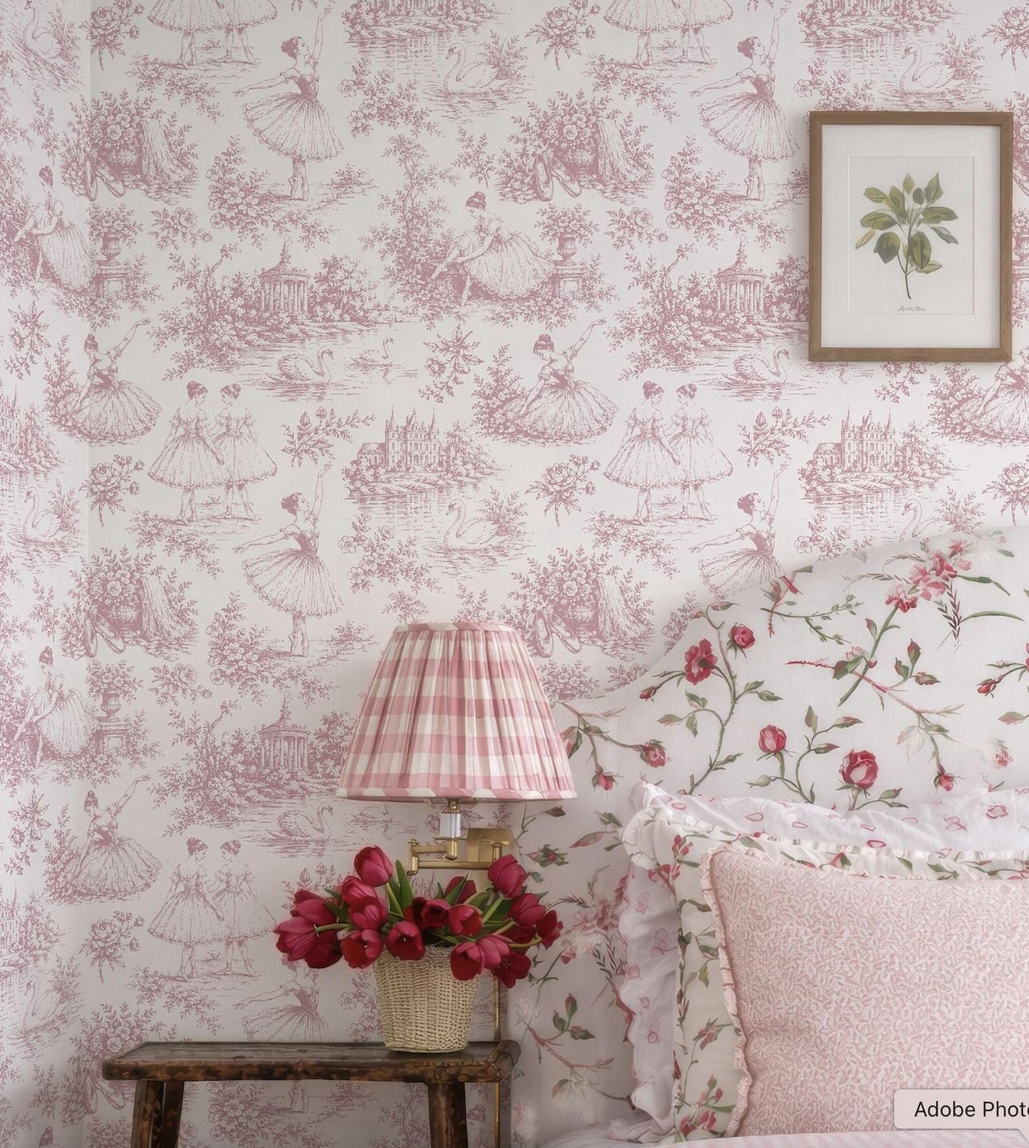 a bedroom with a pink and white floral wallpaper, a wooden nightstand with a lamp and a vase of red flowers, and a framed picture on the wall.