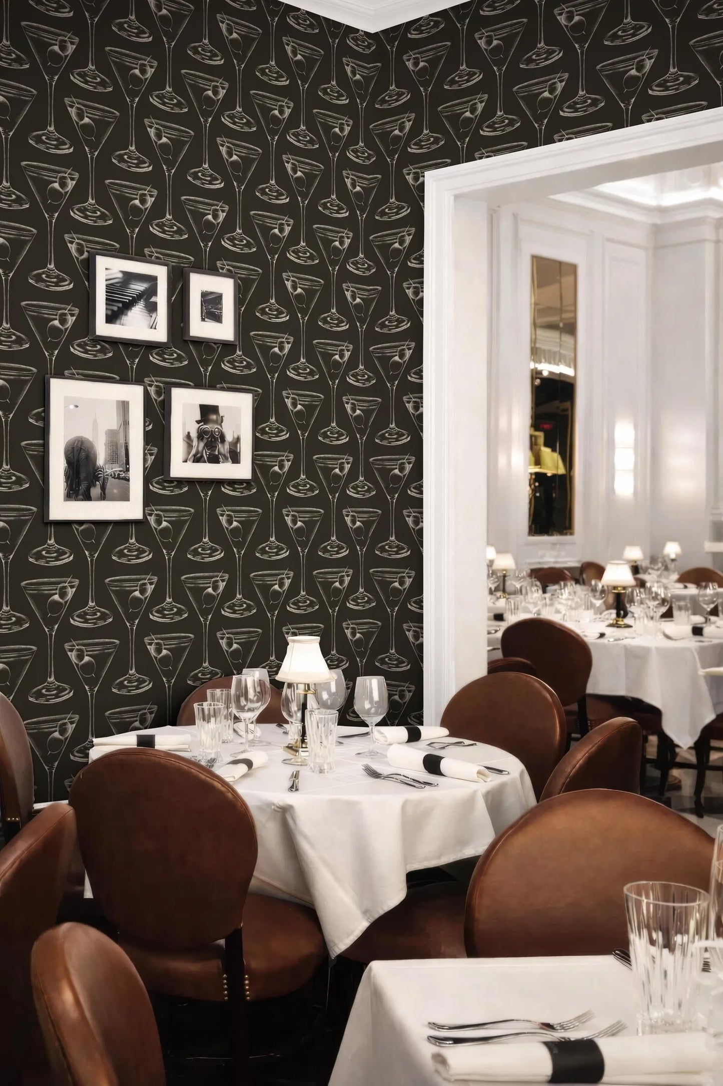 a restaurant setting with a black and white patterned wallpaper, a table set with white tablecloths, and a variety of wine glasses and other tableware.