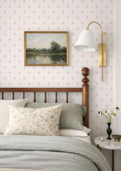 a cozy bedroom with a wooden headboard, a painting on the wall, and a lamp on the wall.