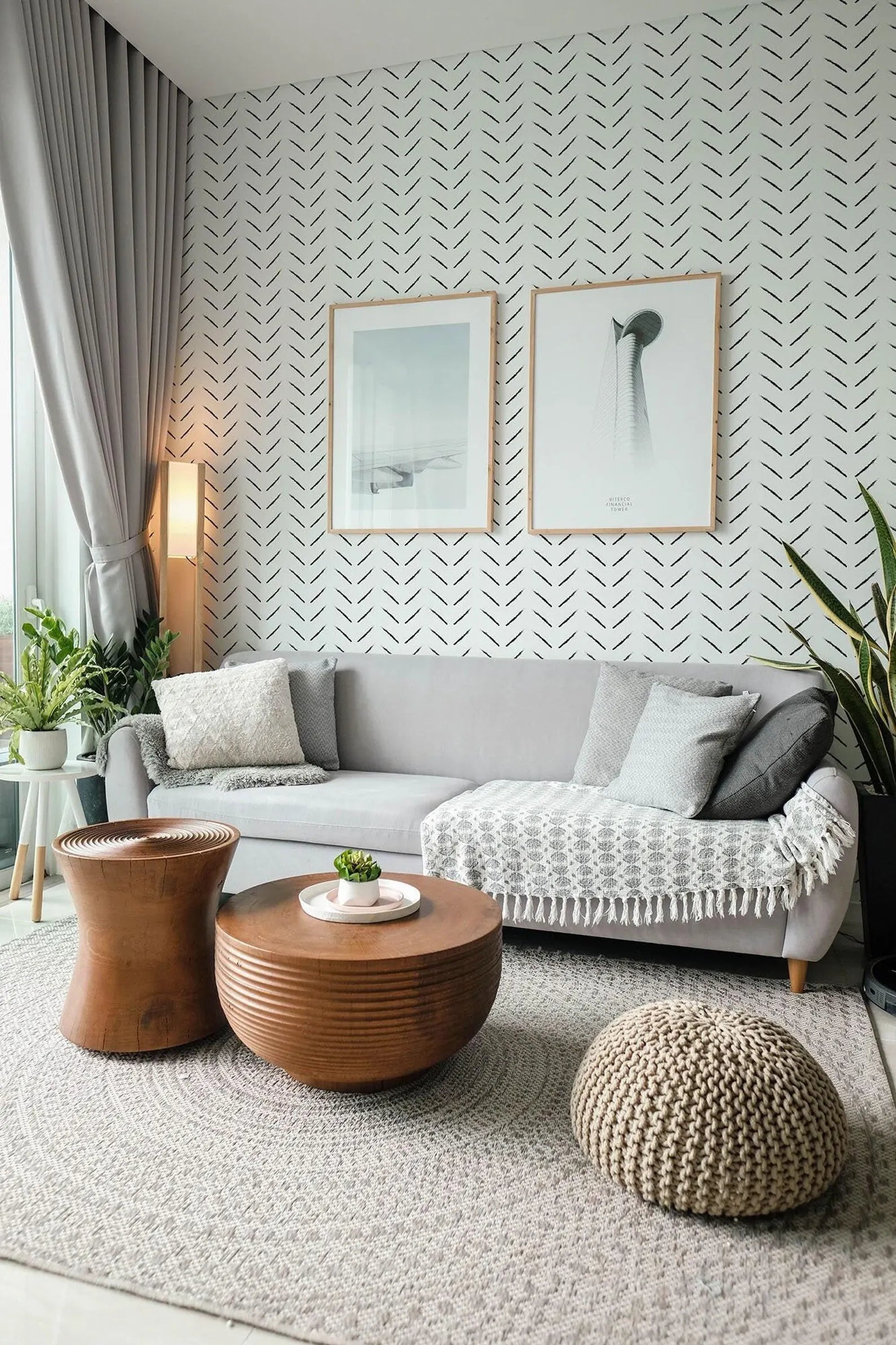 a modern living room with a gray sofa, wooden coffee table, and two framed artworks on the wall. The room is decorated with a gray and white color scheme, and the furniture and decor create a cohesive and stylish aesthetic.