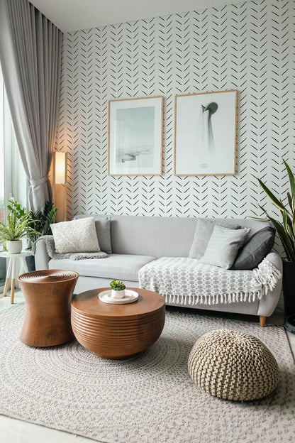 a modern living room with a gray sofa, wooden coffee table, and two framed artworks on the wall. The room is decorated with a gray and white color scheme, and the furniture and decor create a cohesive and stylish aesthetic.