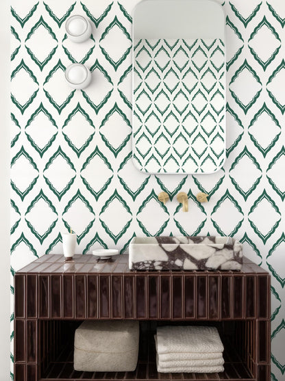 a bathroom with a brown wooden vanity, a marble-topped sink, and a mirror above it. The walls are covered in a patterned wallpaper with green diamond shapes. There are also two white light fixtures on the wall.