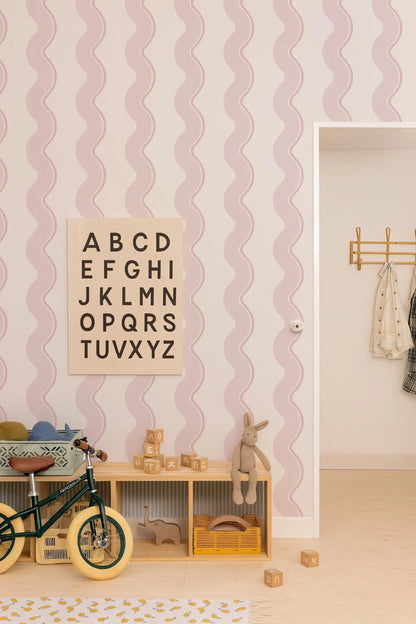 a child's bedroom with a pink and white striped wallpaper, a wooden toy shelf, a bicycle, and a toy rabbit.