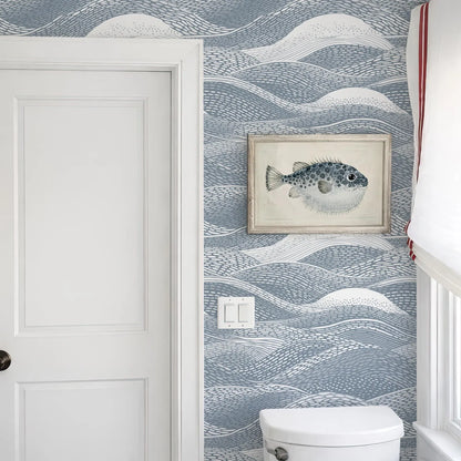 a bathroom with a white door, a framed picture of a fish on the wall, and a white toilet.